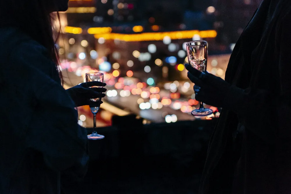 Woman holding wine glass with bokeh lights