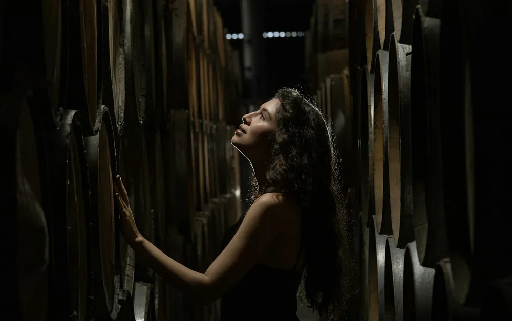Woman looking up among stacked barrels